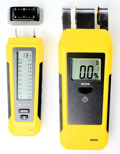 Two yellow moisture meters, one with pins and one pinless, side by side